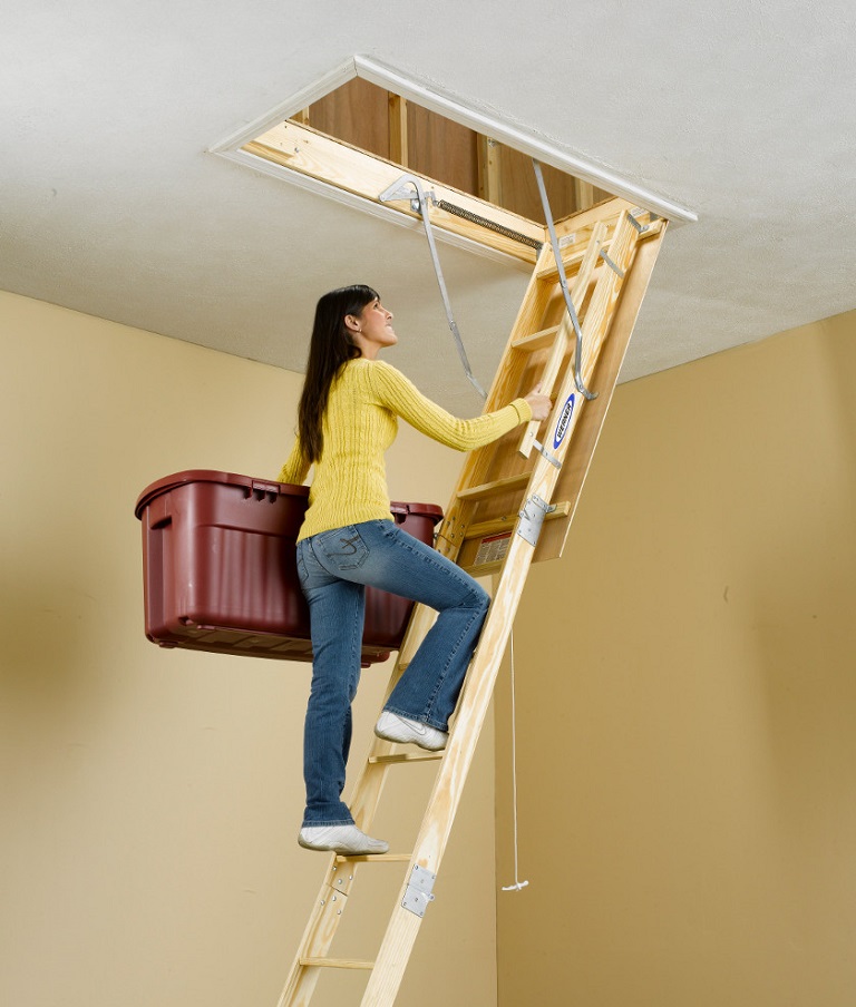 Woman climbing a Werner wood attic ladder